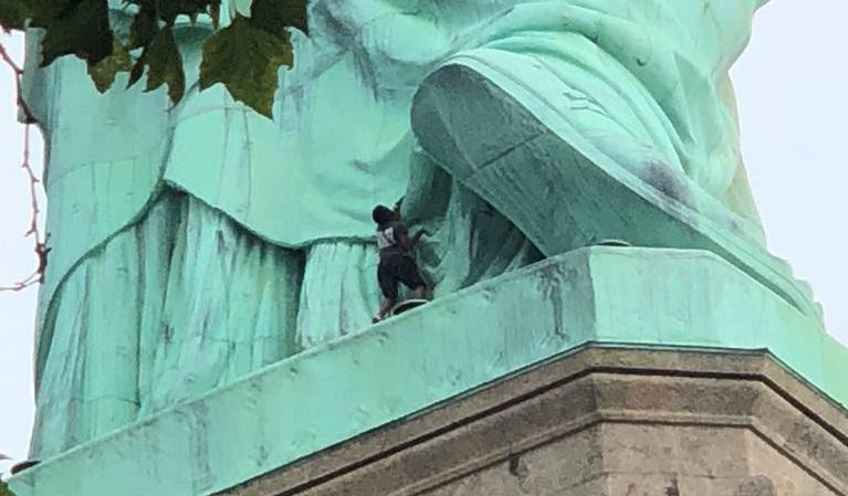 Mujer protesta en la Estatua de la Libertad, Reuters
