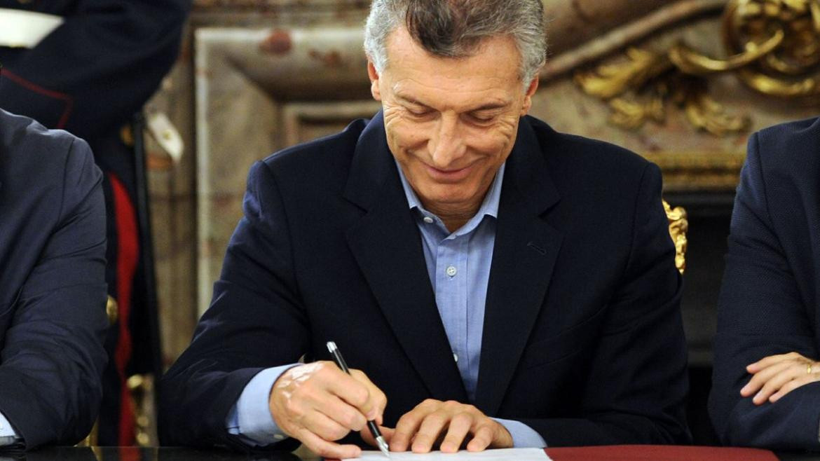 Mauricio Macri firmando, ventas de bienes del Estado, política