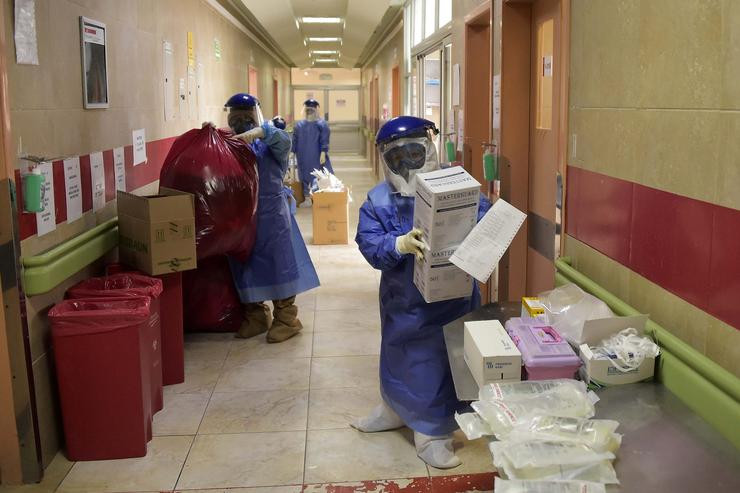 Trabajadores médicos organizan los desechos y suministros en hospital en Quito, coronavirus