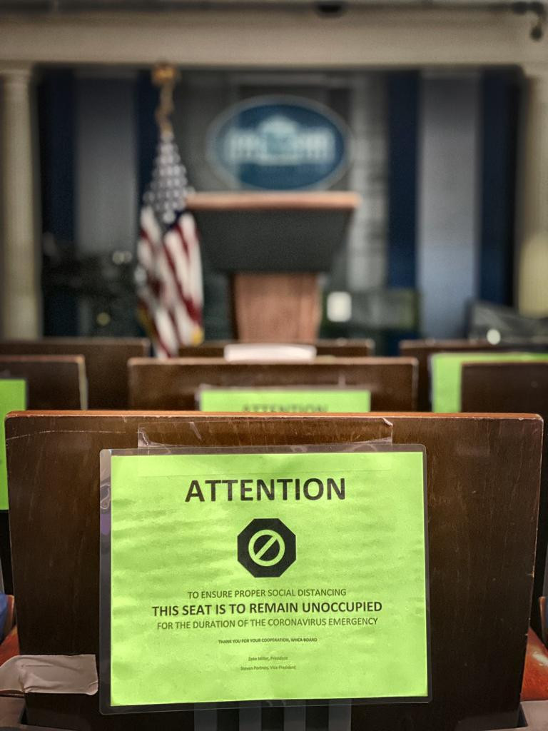 Asientos de la sala de prensa de la Casa Blanca con los avisos contra el COVID-19
