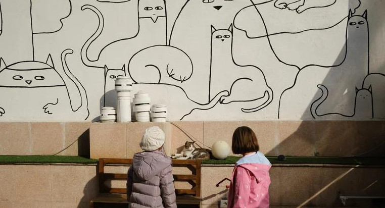 Dos niñas juegan con un gato en el café Museo del Gato Persa en Teherán, foto EFE