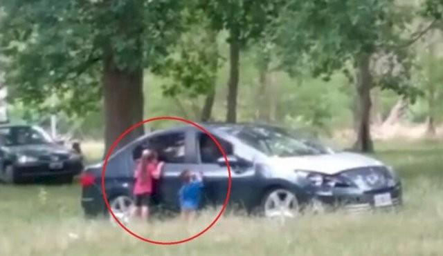 Niños fuera de un auto con sus padres dentro en el Parque Pereyra Iraola