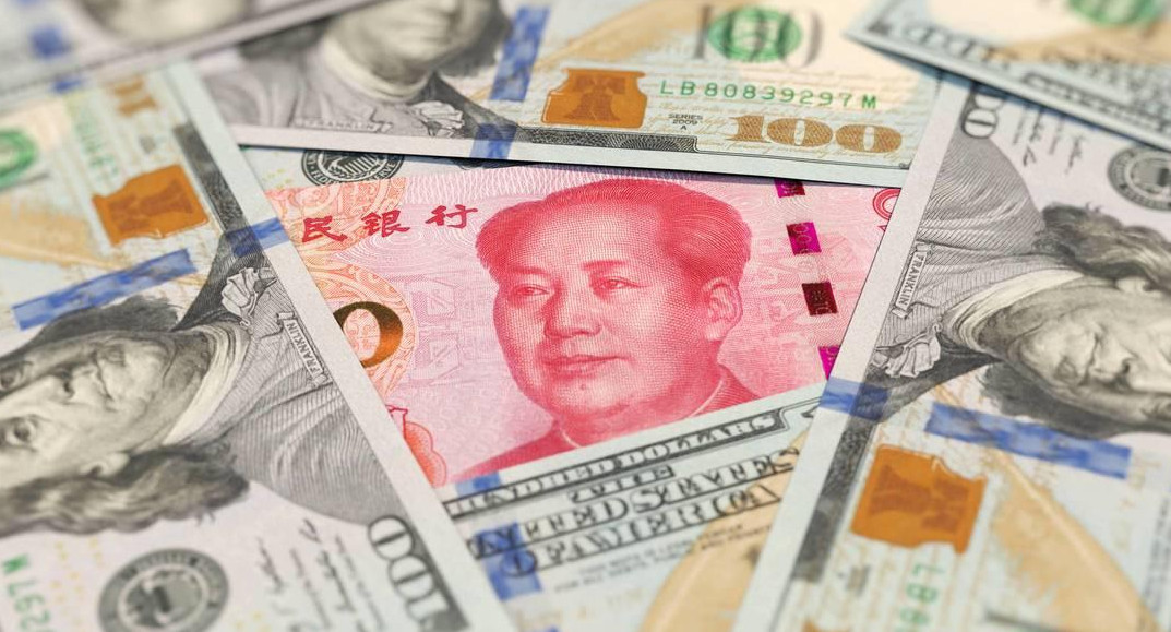 Moneda china y moneda estadounidense. Foto: EFE.
