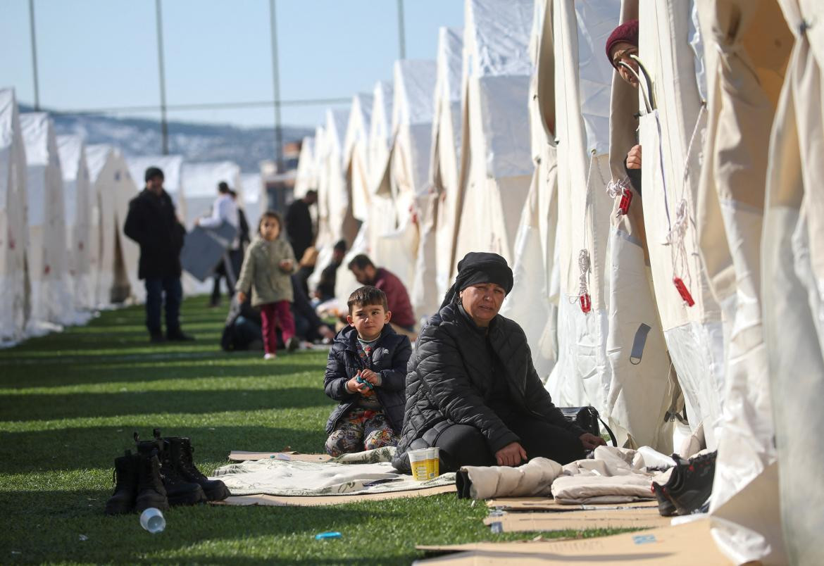Personas en refugios ambulatorios en una cancha de fútbol. Foto: Reuters