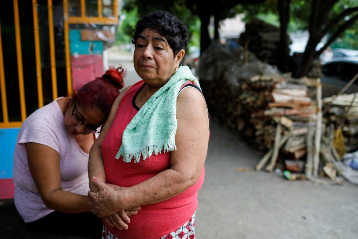 Vilma Gutiérrez, madre de Carlos Alberto Pacheco Gutiérrez, que murió durante un incendio en un centro de detención de migrantes en Ciudad Juárez, México, es consolada por su hija fuera de su casa en Sonzacate
