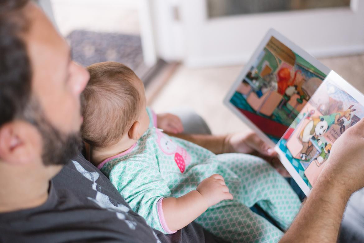 Bebé mirando libro infantil. Foto: Unsplash