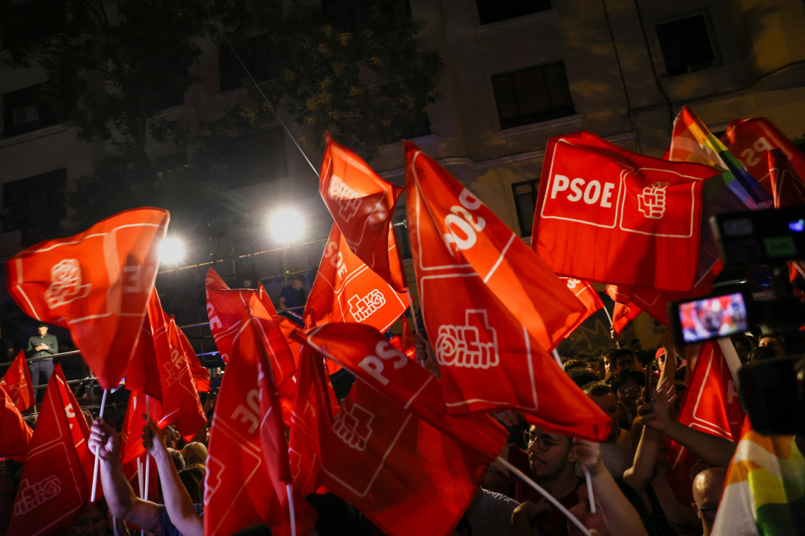 Partidarios del Partido Socialista de España agitan banderas mientras esperan los resultados de las elecciones generales de España. Reuters