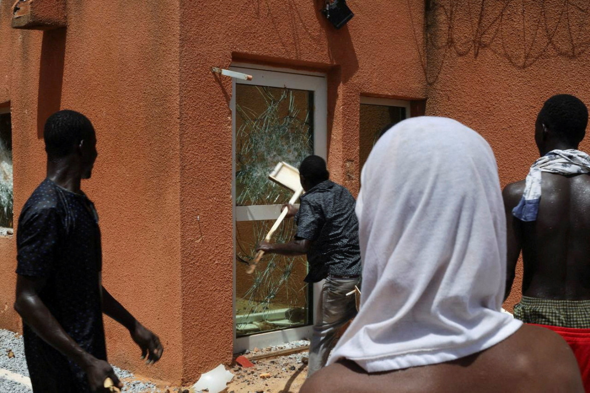 Un manifestante a favor de la junta derriba una de las puertas del edificio de la embajada francesa antes de ser dispersado por las fuerzas de seguridad de Níger en Niamey, la capital de Níger.nReuters