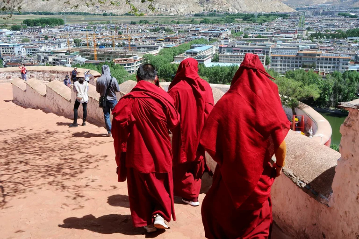 Monjes budistas tibetanos caminan por los terrenos del Palacio de Potala. Foto: Reuters