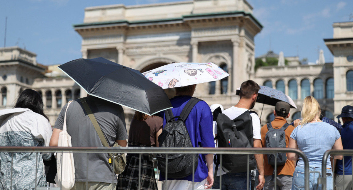 La gente usa sombrillas para esconderse del sol, mientras hacen cola para entrar en la Catedral del Duomo de Milán, durante una ola de calor. Foto: Reuters.