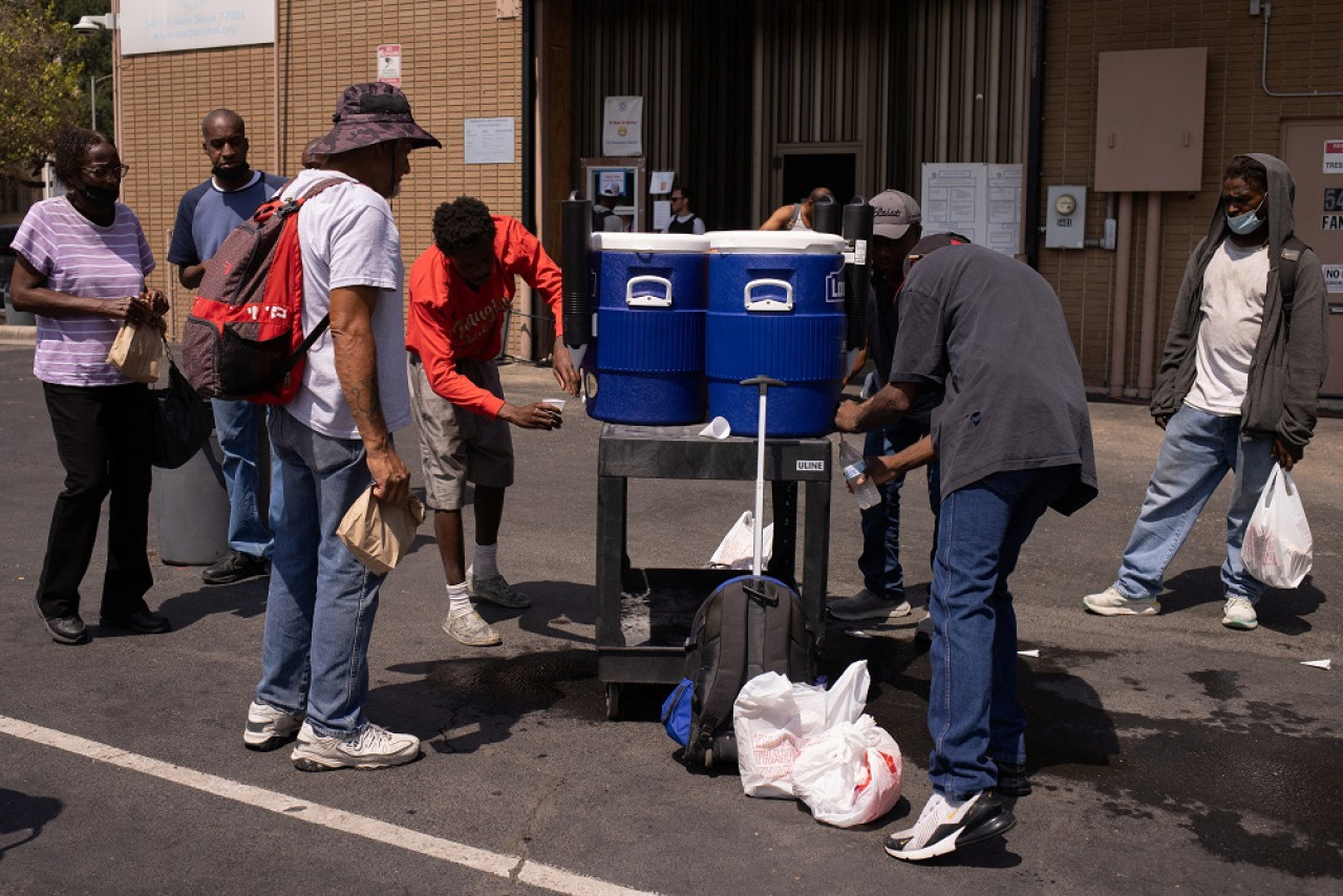 La gente bebe agua fría fuera de la Coalición de Ayuda de Emergencia durante una ola de calor en Houston, Texas, Estados Unidos. Foto: Reuters.