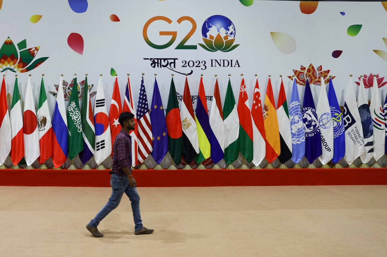 Un hombre camina cerca de banderas antes de la Cumbre del G20. Foto: Reuters.