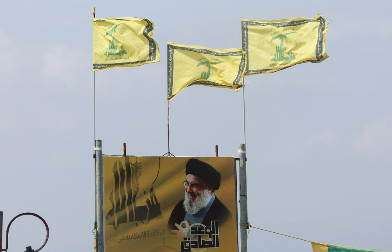 Las banderas de Hezbollah ondean sobre un cartel que representa al líder Sayyed Hassan Nasrallah. Foto: Reuters.