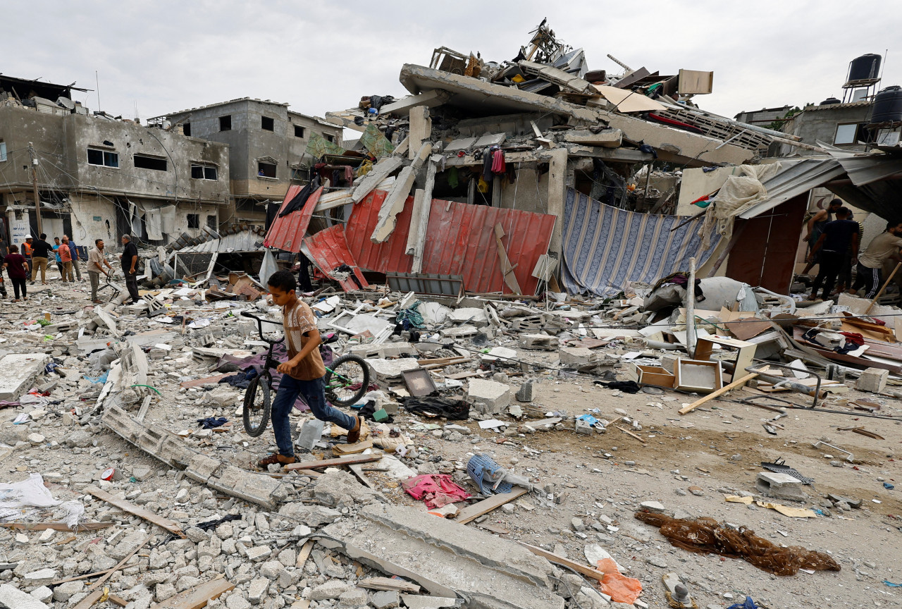 Un niño camina en el lugar de un ataque aéreo israelí contra una casa, mientras continúa el conflicto entre Israel y el grupo islamista palestino Hamás, en Jan Yunis, en el sur de la Franja de Gaz. Reuters