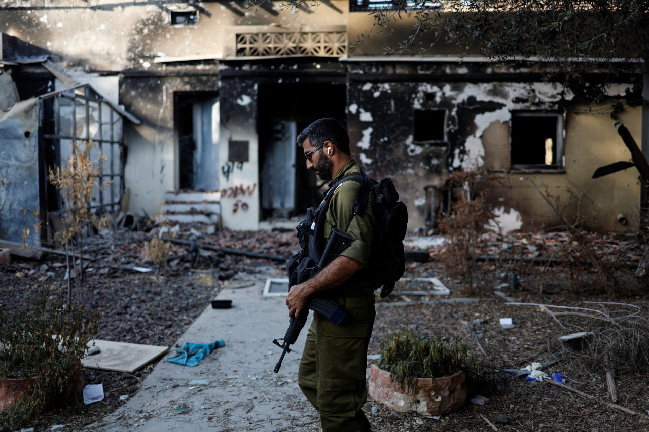 Soldado israelí pasa por delante de una casa dañada tras un ataque mortal de Hamás desde la Franja de Gaza. Reuters