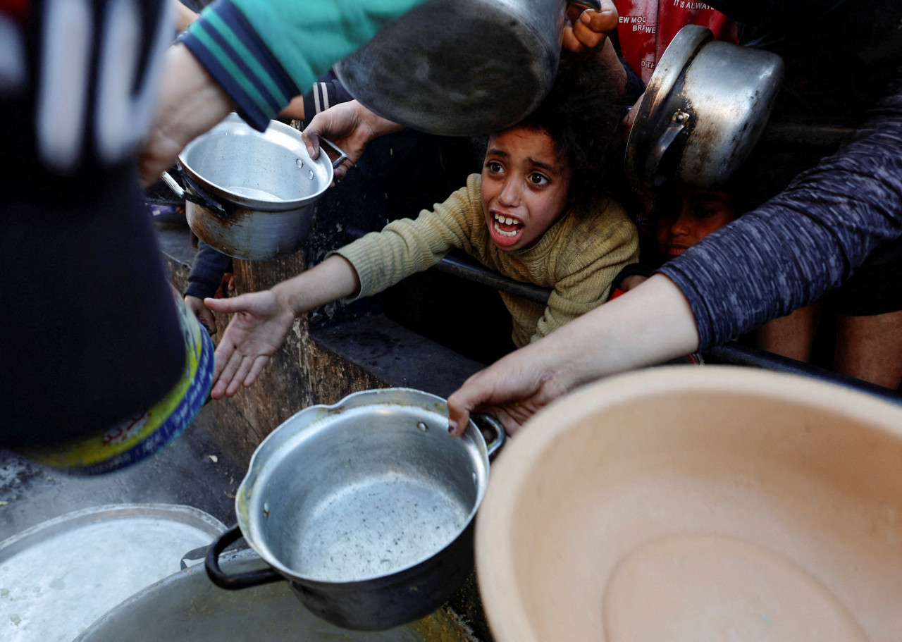 Niños palestinos piden ayuda humanitaria en Gaza. Foto: Reuters.
