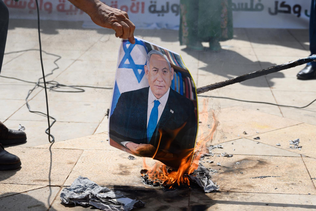Manifestantes queman una fotografía del primer ministro israelí Benjamín Netanyahu. Efe