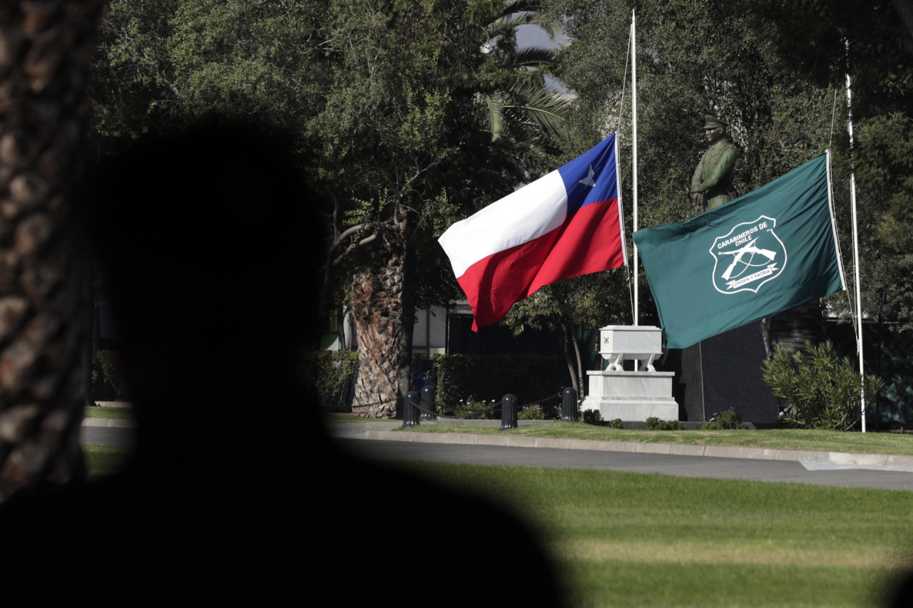 Las banderas de Chile y la institución de Carabineros, a media asta. Foto:  EFE