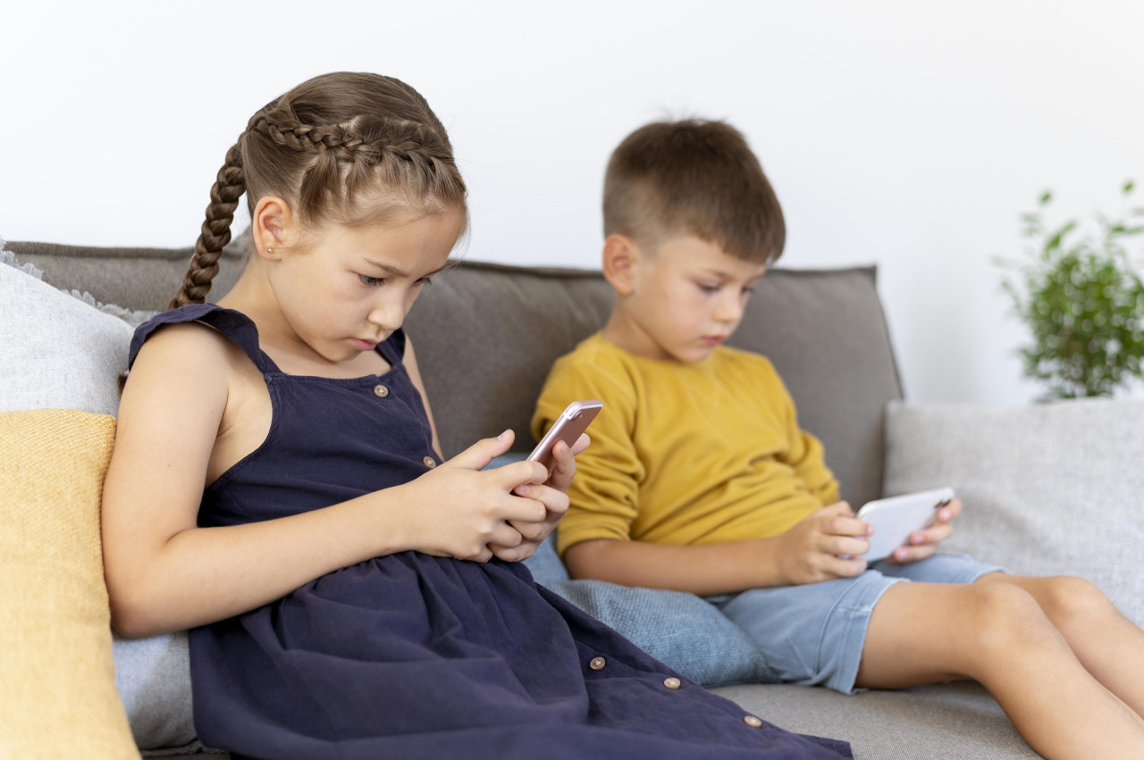 Niños usando el celular. Foto FREEPIK