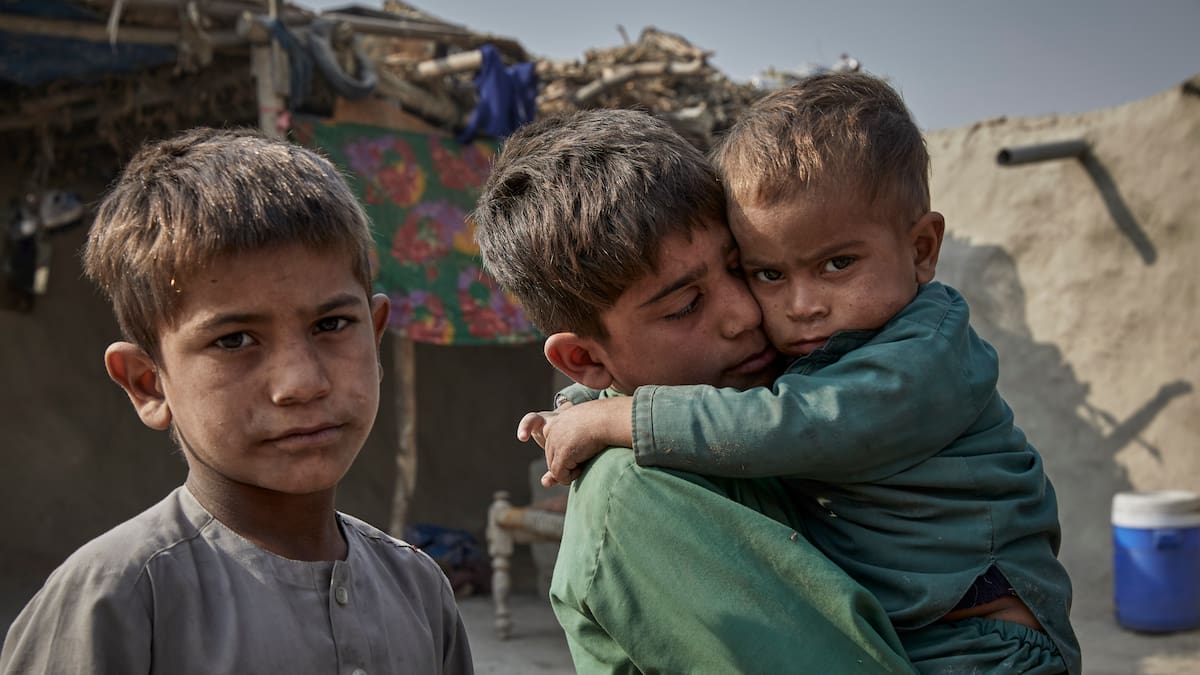 Niños desplazados internamente en un refugio temporal en Jalalabad, Afganistán. Uno de ellos lleva a su hermano enfermo en brazos.