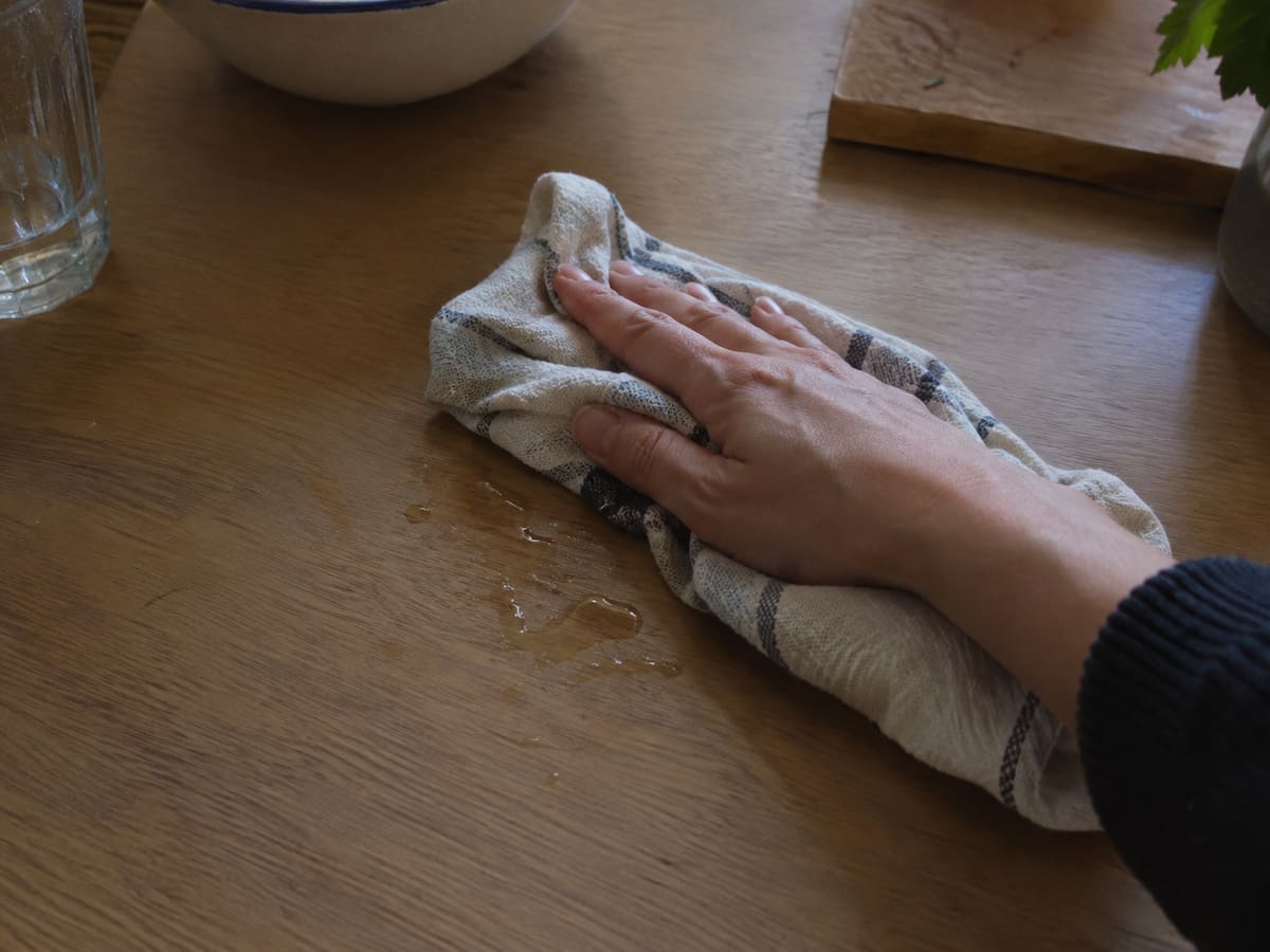 Mano limpiando una mesada de cocina