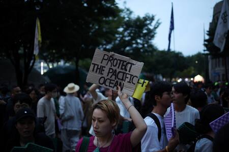 Una mujer sostiene una pancarta durante una protesta contra el plan de Japón de liberar al océano aguas residuales tratadas de la central nuclear de Fukushima. Foto: Reuters.