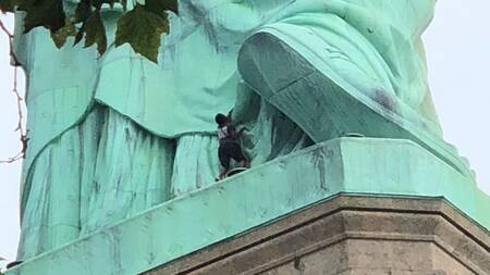 Mujer protesta en la Estatua de la Libertad, Reuters