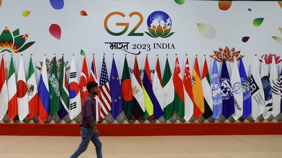 Un hombre camina cerca de banderas antes de la Cumbre del G20. Foto: Reuters.