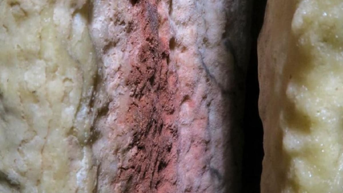 Marcas rojas encontradas en una estalagmita en la caverna de Ardales (en Málaga, España), que podrían ser las pinturas rupestres más antiguas del mundo conocidas hasta ahora. Imagen cedida por la Universidad de Cádiz.