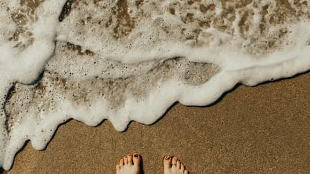 Los pies se ensucian en la playa. Foto: Unsplash.