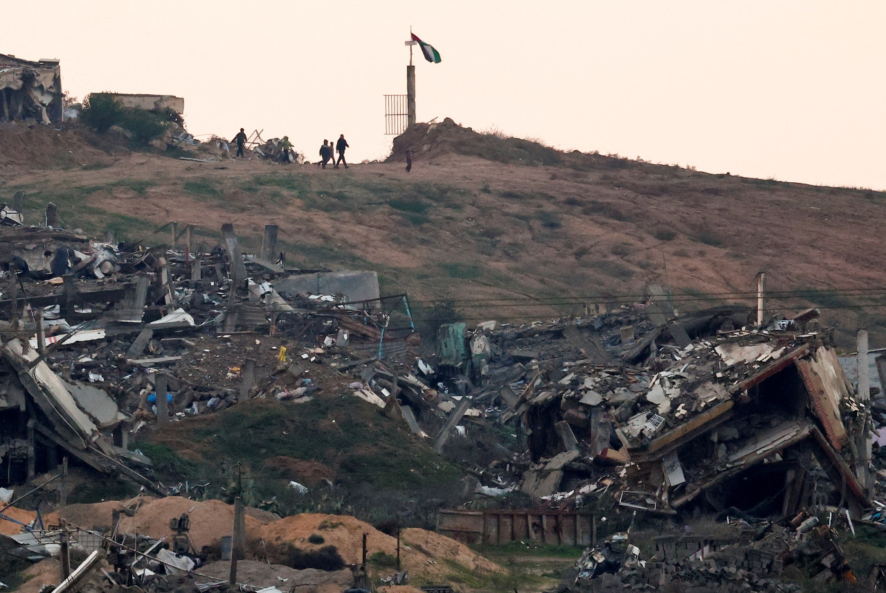Palestinos caminan en las cercanías a ruinas en Gaza. Foto: Reuters/Amir Cohen.