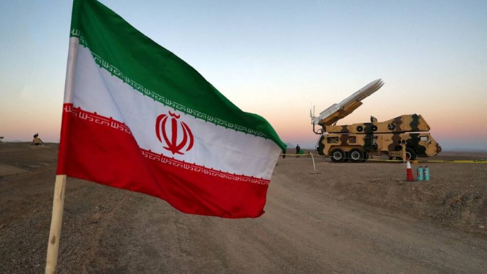 Una bandera iraní es fotografiada cerca de un misil. Foto: Reuters.