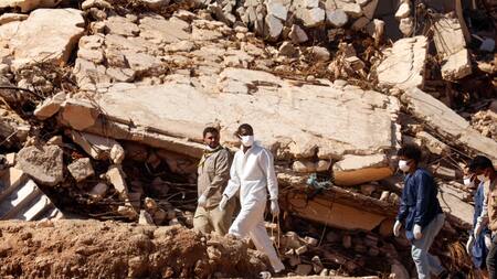Rescatistas caminan frente a edificios que se derrumbaron durante las inundaciones después de "Daniel". Télam