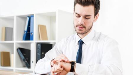 Trabajador mirando el reloj. Foto: Freepik.
