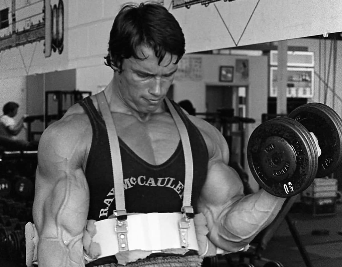 Foto antigua de Arnold Schwarzenegger entrenando su físico de joven.