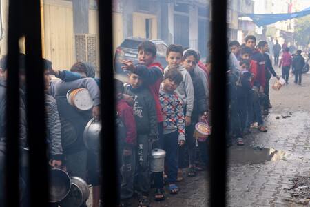 Niños palestinos esperan recibir comida cocinada en una cocina benéfica, en Rafah, Gaza. Reuters
