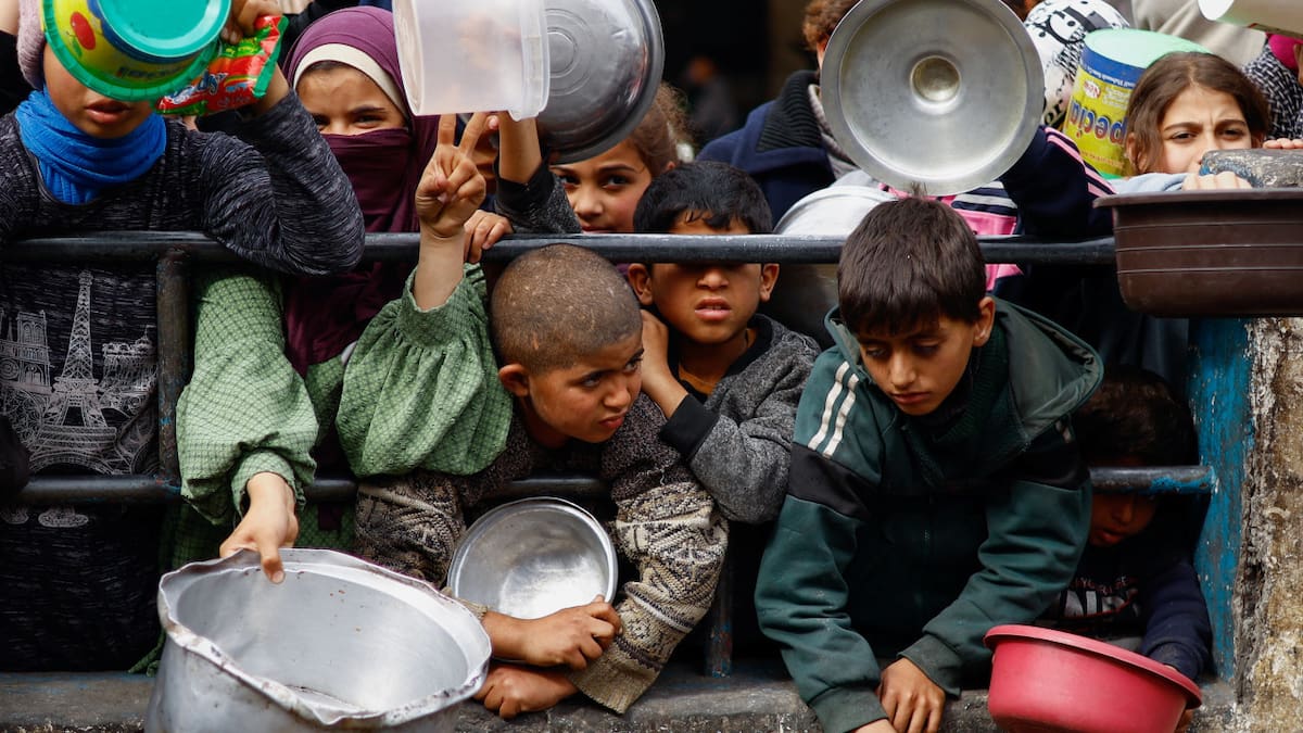 Niños en campo de refugiados en Rafah, Gaza, pidiendo comida. Foto: Reuters.