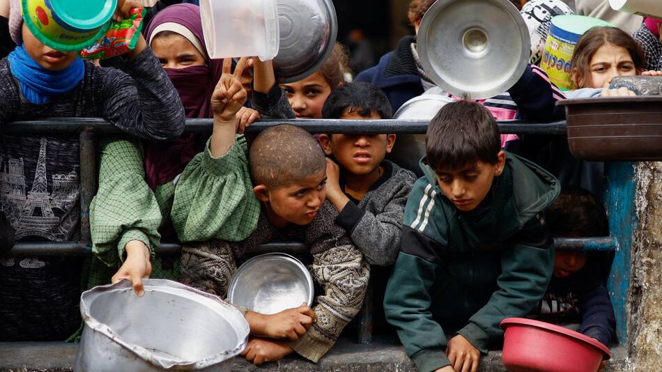 Niños en campo de refugiados en Rafah, Gaza, pidiendo comida. Foto: Reuters.