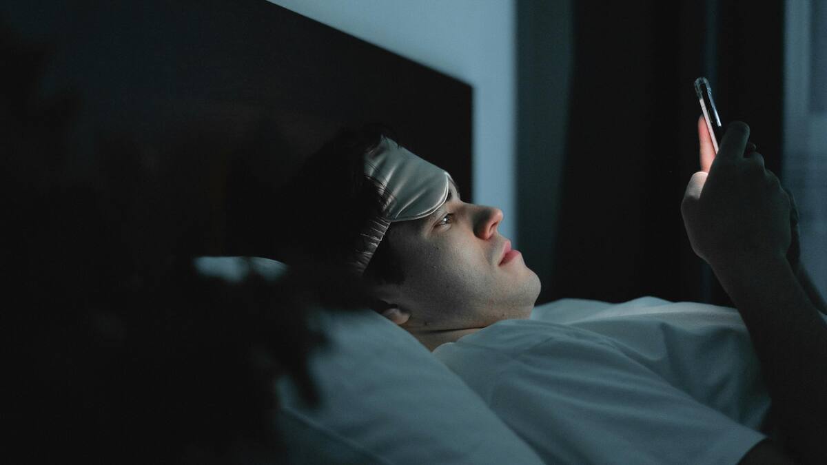 Celular en la cama. Fuente: Pexels.