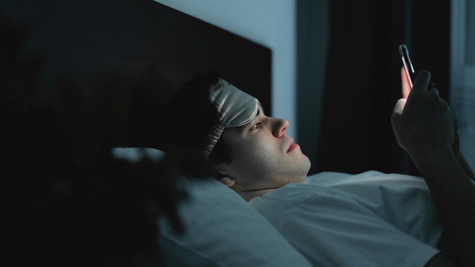 Celular en la cama. Fuente: Pexels.