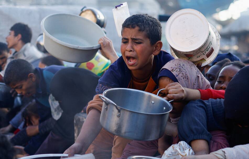 Niños palestinos esperan recibir alimentos durante el Ramadán, en Rafah. Efe
