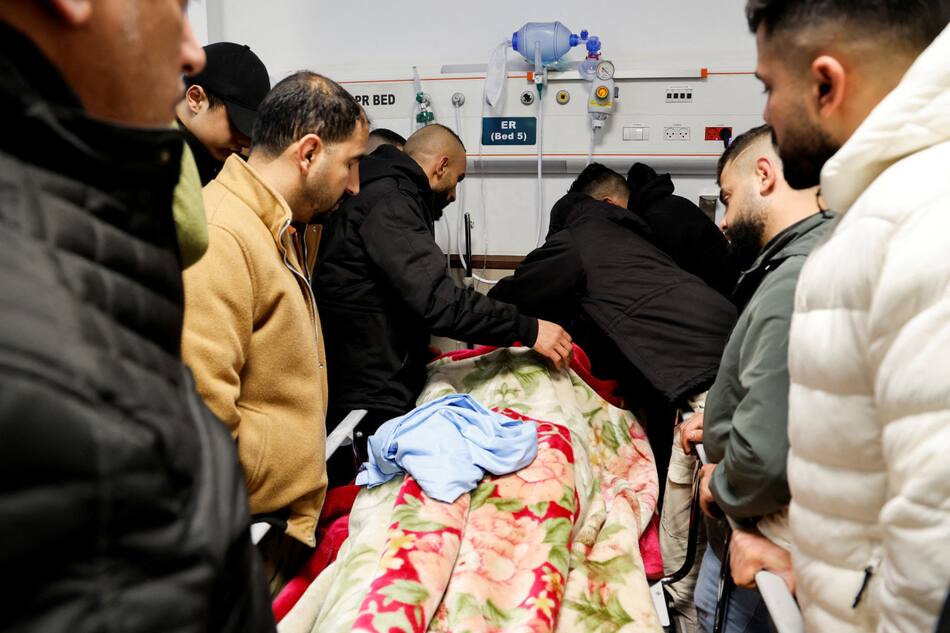 Personas alrededor de los cuerpos asesinados en la operación israelí. Foto: Reuters.