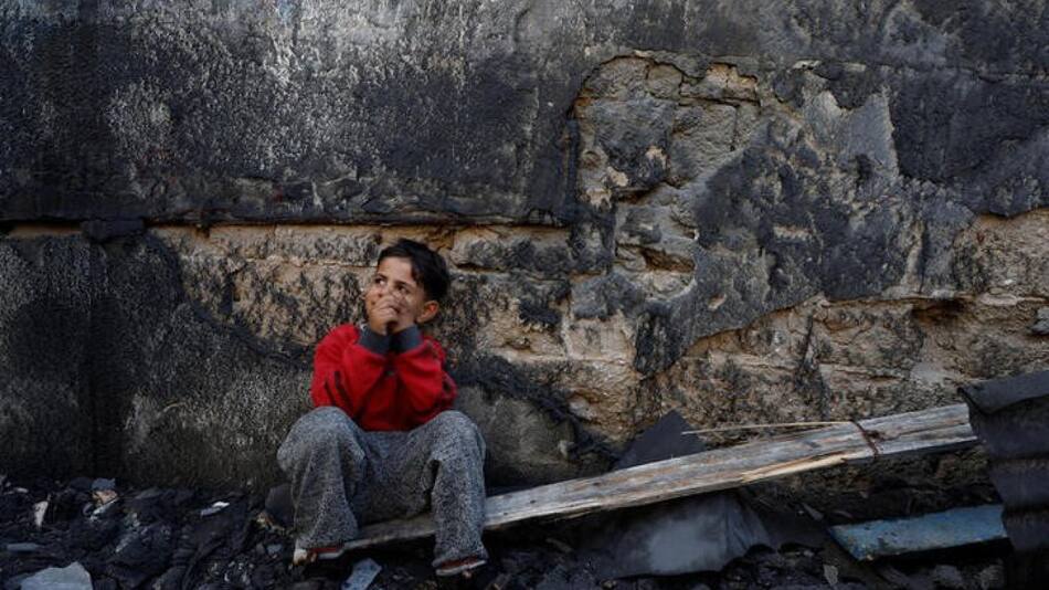 un niño palestino sentado junto a unos escombros en Jan Yunis, en el sur de la Franja de Gaza.. Reuters