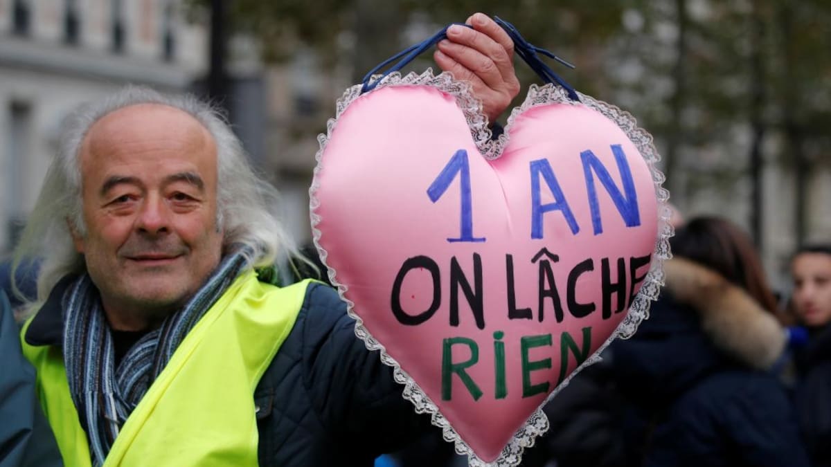 Un manifestante sostiene una almohada en forma de corazón con el lema "1 año y no renunciamos", Chalecos amarillos, Francia, REUTERS
