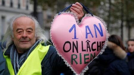 Un manifestante sostiene una almohada en forma de corazón con el lema "1 año y no renunciamos", Chalecos amarillos, Francia, REUTERS