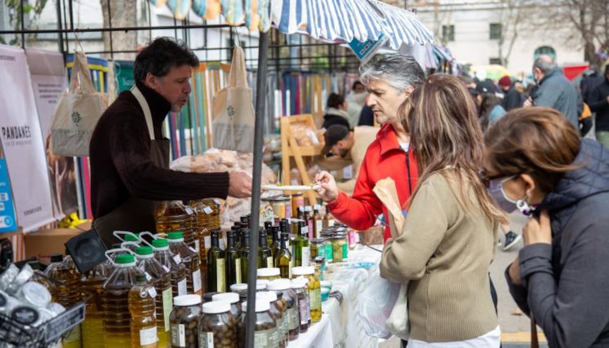 Puestos de la feria Nuevos Sabores con visitantes recorriendo el Parque Rivadavia en el barrio de Caballito.