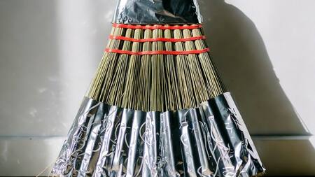 Escoba envuelta con papel aluminio