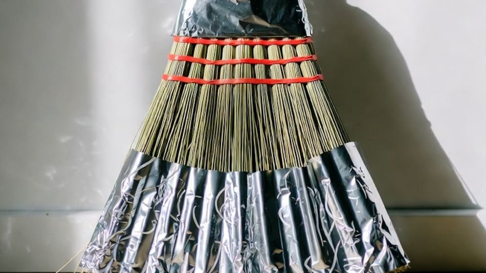 Escoba envuelta con papel aluminio