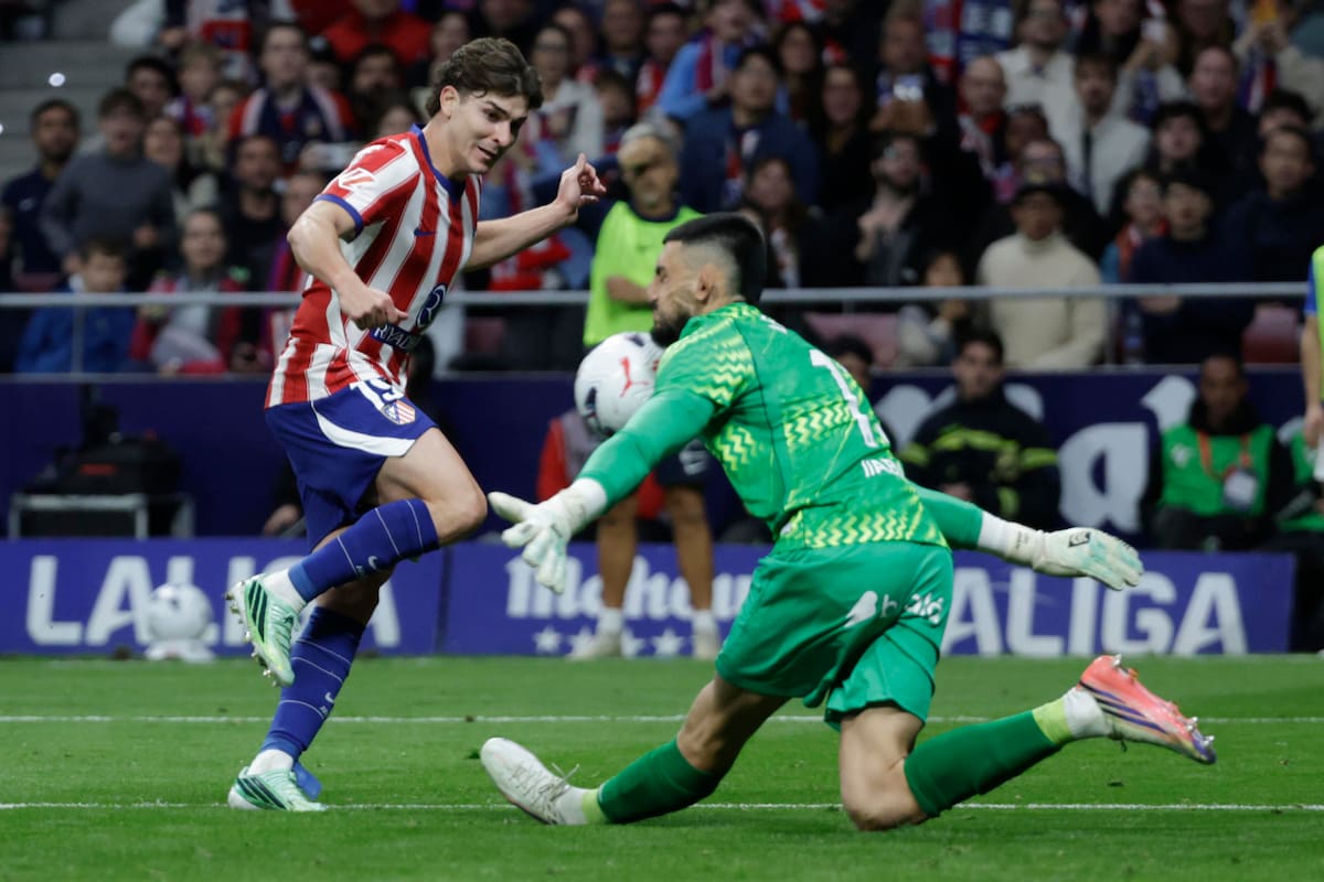 El delantero argentino del Atlético de Madrid, Julián Álvarez (i), remata ante el arquero del Deportivo de La Coruña, Leo Román.