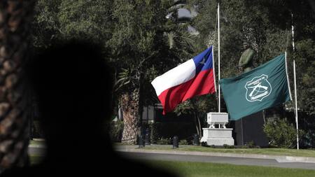 Las banderas de Chile y la institución de Carabineros, a media asta. Foto: EFE